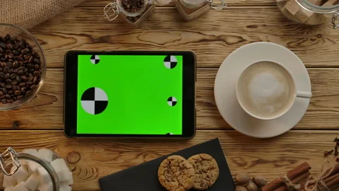 Digital tablet with green screen lying horizontally on wood desk. Eat,drink,work Stock Footage 136815636