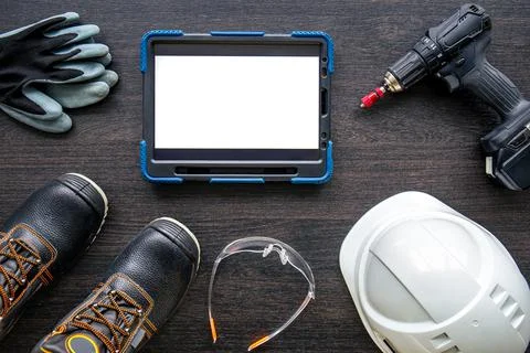 Digital tablet with layout and worker clothes, top view. Stock Photos