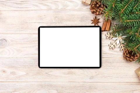 Digital tablet mock up with rustic Christmas wood background decorations fo.. Stock Photos