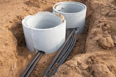Digital telecommunication network pipes hold cables buried underground. Man.. Stock Photos