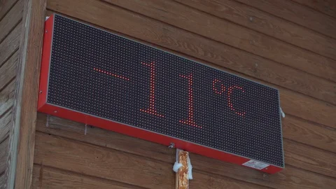 A digital thermometer on the facade of the building shows a negative temperature Stock Footage 124007850
