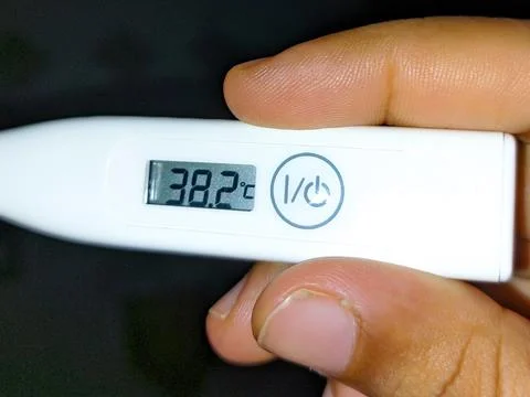 Digital thermometer showing elevated body temperature, a sign of fever. Stock Photos