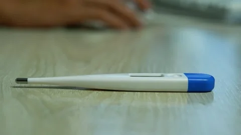 Digital thermometer on a wooden table, Close-up of a white and blue digital.. Stock Footage 346484671