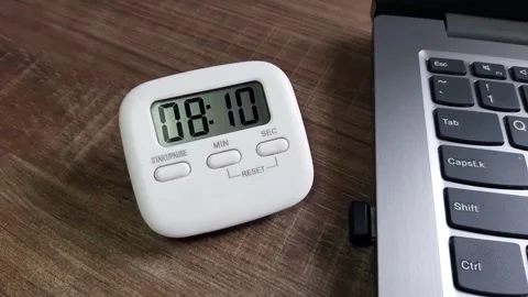 Digital timer counting down on the working desk next to the laptop	 Stock Footage 285911535