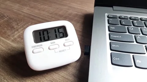Digital timer counting down on the working desk next to the laptop	 Stock Footage 285911538