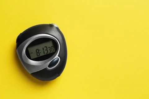 Digital timer on yellow background, top view. Space for text Foto stock