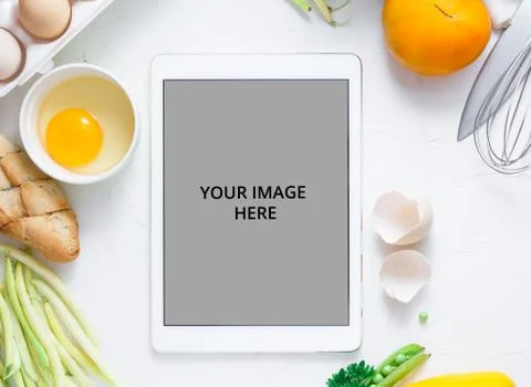 Digital touch screen tablet with fresh vegetables and kitchen utensils on Stock Photos