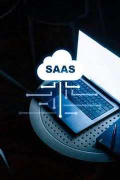 Digital workspace with laptop and cloud symbol representing Software as a Stock Photos