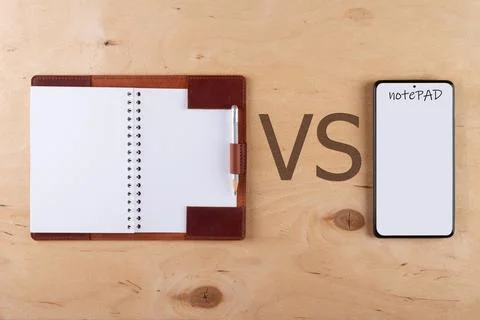 Digitalization concept. Paper notebook vs smartphone. Stock Photos