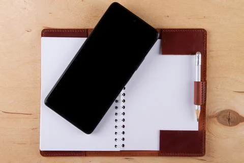 Digitalization concept. Paper notebook vs smartphone. Stock Photos