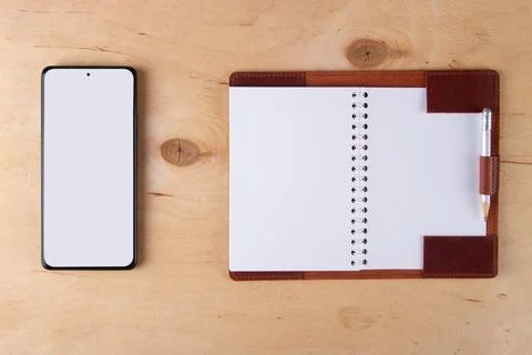 Digitalization concept. Paper notebook vs smartphone. Stock Photos