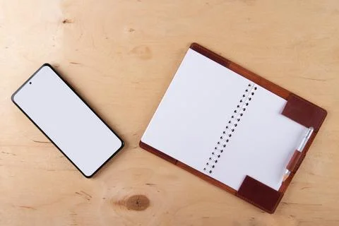 Digitalization concept. Paper notebook vs smartphone. Stock Photos