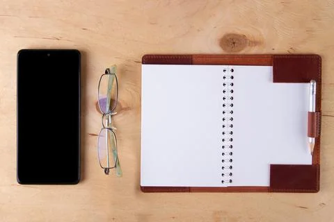 Digitalization concept. Paper notebook vs smartphone. Stock Photos
