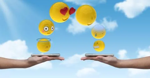 Digitally generated image of emojis flying over hands holding smart phone Foto stock