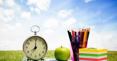 Digitally generated image of school equipment against green grass and blue sky Foto stock