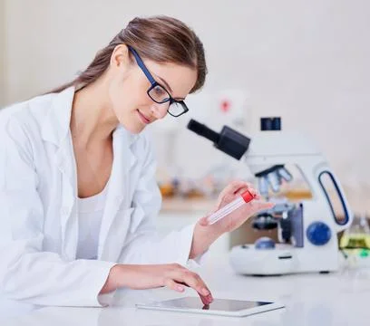 Digitally tracking her progress. Shot of a scientist using a digital tablet a Stock Photos