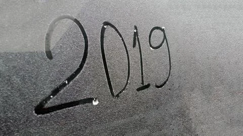 Digits 2019 written on the window with snow background Stock Photos