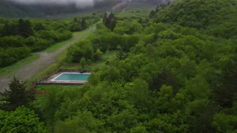 DIGORA GORGE, NORTH OSSETIA - JUNE 1, 2024: Aerial view of secluded outdoor pool Stock Footage 337462697