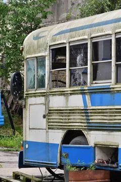 Dilapidated and rusty bus with broken windows in a remote area. Scrap. Stock Photos
