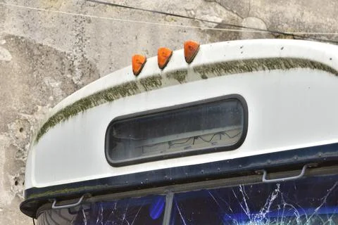 Dilapidated and rusty bus with broken windows in a remote area. Scrap. Stock Photos