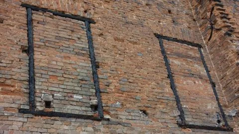 Dilapidated brick wall with two burned out frames Stock Photos