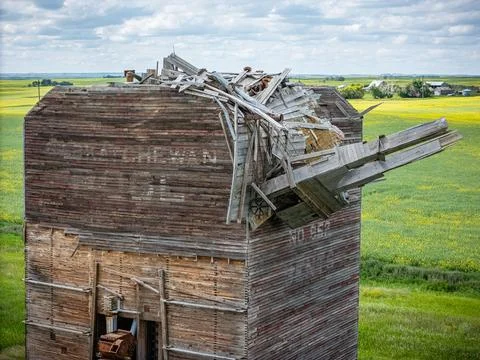 Dilapidated grain elevator with a broken roof and a pile of debris on top Stock Photos