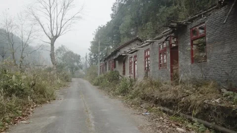 Dilapidated Gray Brick Buildings with Broken Roofs Along Foggy Mountain Road Stock Footage 335462321