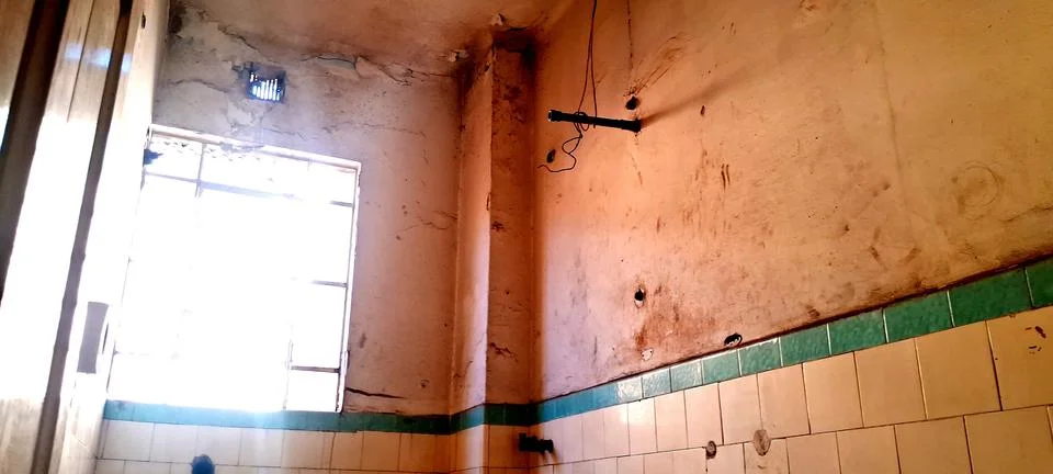Dilapidated interior room with bright window light and peeling walls Stock Photos