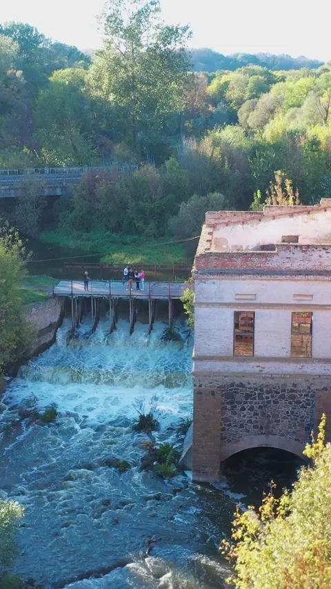A dilapidated mill by the river with a dam. Vertical video. Stock Footage 288218693