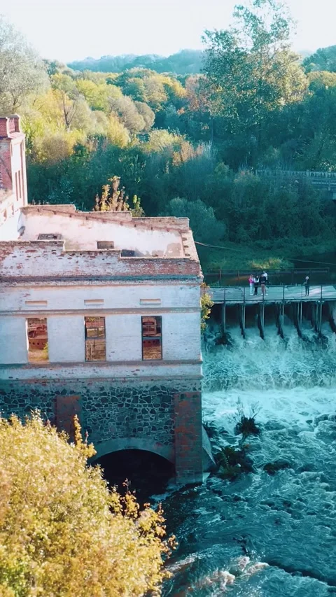 A dilapidated mill by the river with a dam. Vertical video. Stock Footage 288218781
