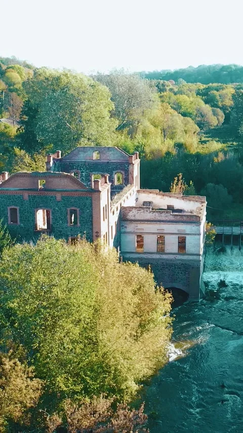 A dilapidated mill by the river with a dam. Vertical video. Stock Footage 288218953