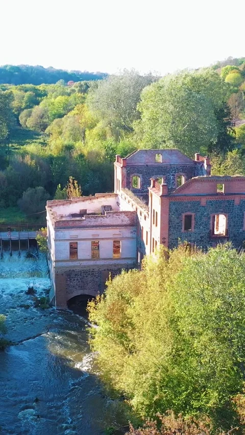 A dilapidated mill by the river with a dam. Vertical video. Stock Footage 288218961