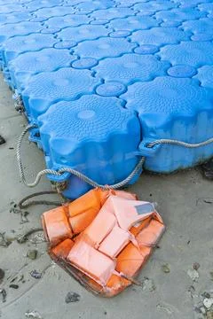 Dilapidated old floating plastic pontoon platform with life jacket abandoned Stock Photos