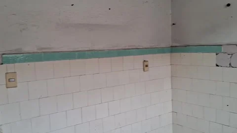 Dilapidated room walls featuring damaged retro tiles Stock Footage 345975585