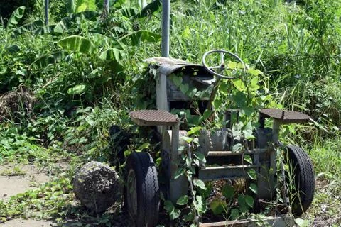 Dilapidated rustic old farm tractor left in vicinity of agricultural campus Stock Photos