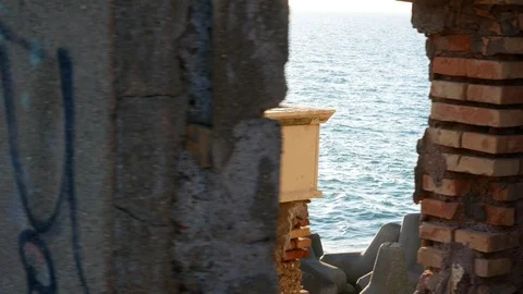 Dilapidated structure of an old lighthouse full of graffiti, sea view Stock Footage 101225777