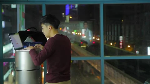 Diligent Asian boy is working on trash bin at subway station by using his laptop Video stock 260908705