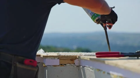 Diligent Construction Professional Close-Up of Hands Applying Foam on Site Stock Footage 250512156