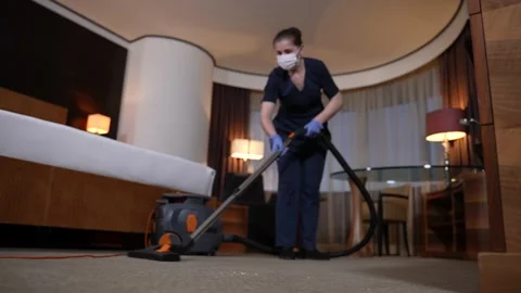 Diligent housemaid vacuuming carpet in hotel room Stock Footage 148111753