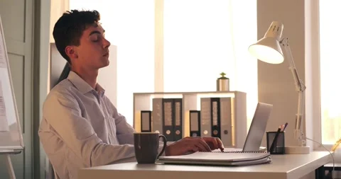 Diligent Manager Typing on Laptop and Stretching at Work Stock Footage 248532292