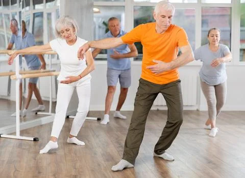 Diligent mature man practicing ballet positions standing in row with others 스톡 사진