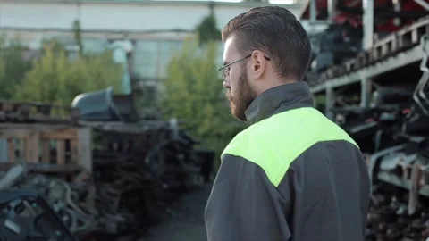 A diligent young bearded mechanic wearing glasses writes down data on spare Stock Footage 136815221