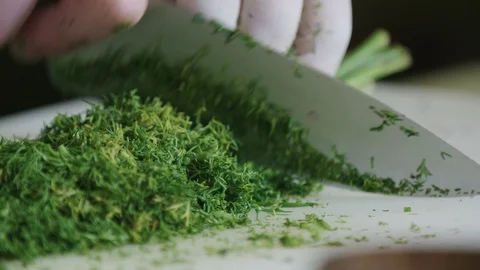 Dill being chopped with a knife in slow motion Stock Footage 129016277