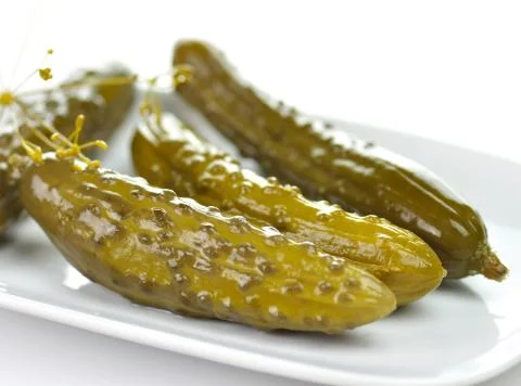 Dill pickles on a white dish Stock Photos