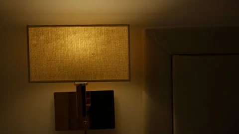 Dim bedside lamp in cozy nighttime interior Stock Footage 306329917