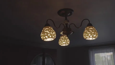 Dim ceiling lamp with patterns illuminates semi-dark premise Stock Footage 241913948