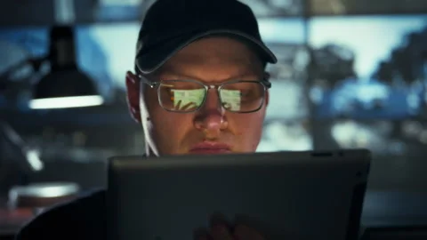 In a dim control room lined with video surveillance monitors an employee in Stock Footage 334546009