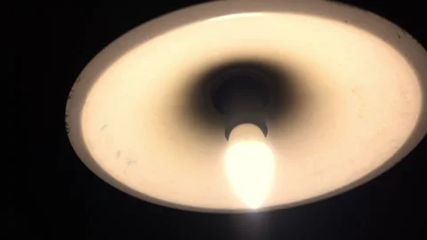 A dim lamp under the ceiling shines in the dark Stock Footage 221177420
