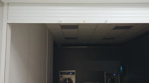 Dim Laundry Room Interior With Washing Machines And Rolling Door Stock Footage 318839280