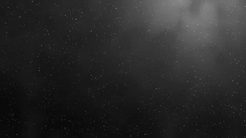 Dim light with billowing smoke and small floating particles against black Stock Footage 346656676